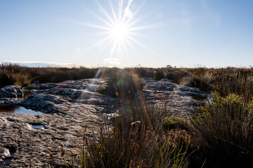 Naklejka premium Sunburst Over Rock Pools on Table Mountain Plateau, Cape Town South Africa