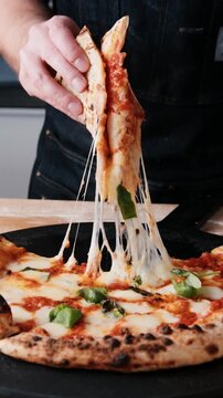 Close up of the ultimate fior di latte mozzarella cheese pull on a hot pizza