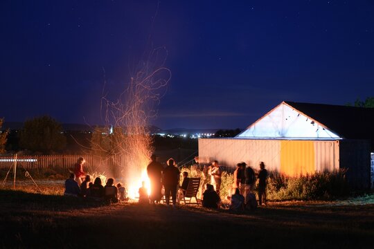 Travel romania transilvania targu mures friends enjoying campfire under starry night sky in transylvania
