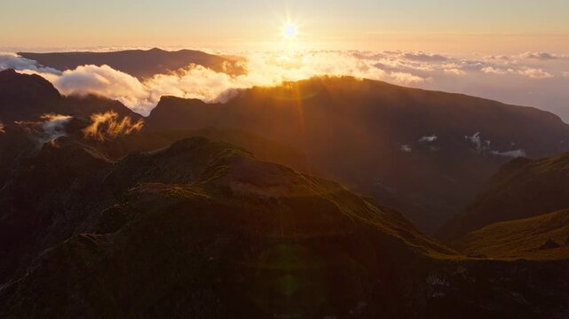 Aerial view of flying at Pico Ruivo of mountains with clouds on sunset. Madeira island, Portugal. Push in approach dolly move