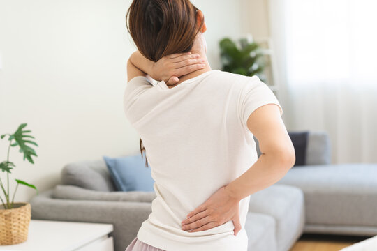 Pain body muscles stiff problem, asian young woman painful back, neck ache from work hand holding massaging rubbing shoulder hurt, sore sitting on bed while wake up at home. Health care and medicine.