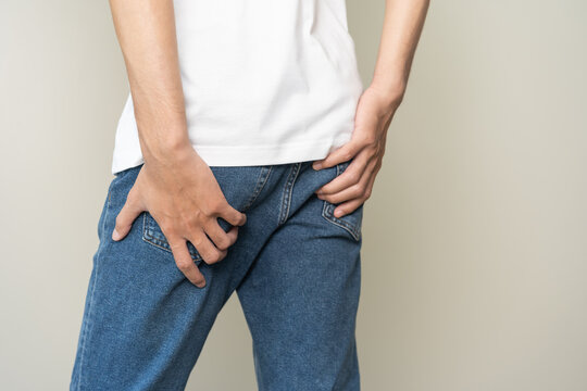 Closeup annoying itch asian man with an itchy his butt from fungal, male scratching crotch with hand, itching groin, male suffering body problem. Health care, hygiene, skin disease, medicine concept