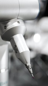 Precision measuring probe of coordinate measuring machine inspecting metal component during industrial quality control and manufacturing measurement process.