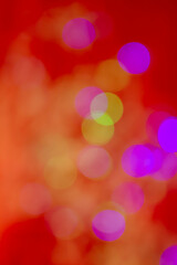 Obraz premium Abstract multicolored bokeh light circles softly blurred over a vivid red background, creating a vibrant and festive atmosphere.