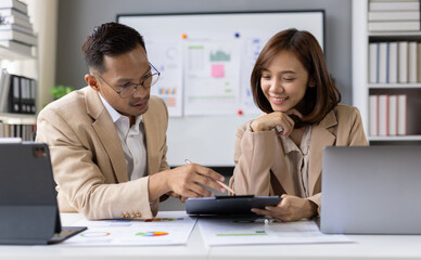 Fototapeta premium Two professional accountants collaborating in office, analyzing financial reports and discussing data insights while working together on a strategic business project.