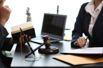 Lawyers discussing contract, working with legal documents, gavel and laptop on desk.