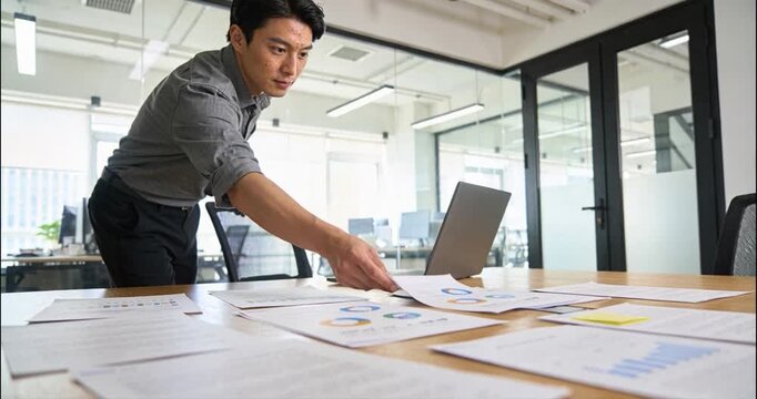 Businessman examining documents at modern office meeting table