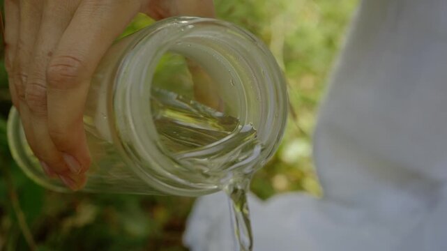 Close up of water and jasmine green tea steeping in a glass teapot under bright forest sunlight outdoors picnic experience during Mediterranean summer day 
