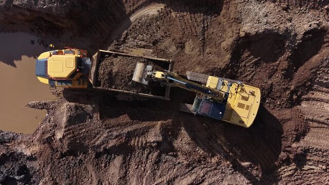 Gr&uacute;a en acci&oacute;n: llenando parcialmente el remolque del dumper en la cantera desde el dron