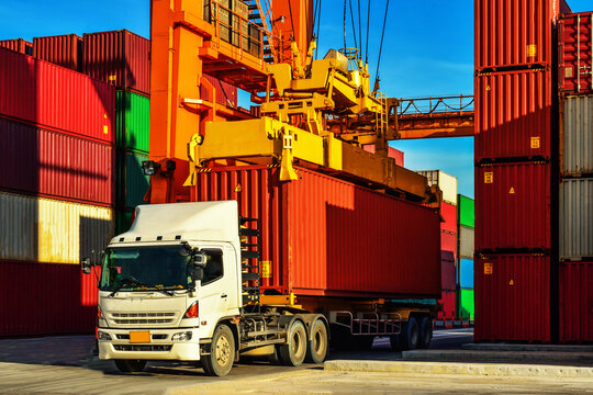 Container handling. Container truck picking up container at yard. Port logistics, container yard operation.
