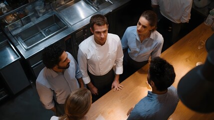 Naklejka premium Restaurant team in professional meeting around a bar counter high angle view