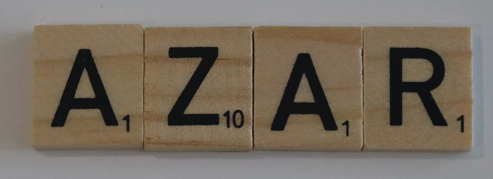 Wooden scrabble tiles spelling out the word azar on a plain background close up studio shot