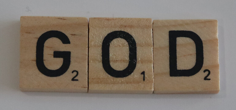 Three wooden letter tiles spelling god with black letters and point values arranged horizontally