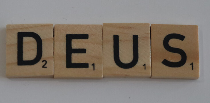 Wooden letter tiles spelling out the word deus arranged in a line against a neutral background