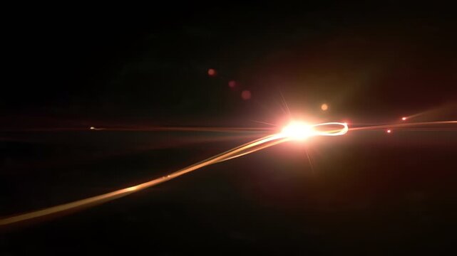 Abstract orange light trails and golden lens flare on black for futuristic motion background