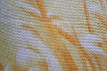 Abstract yellow and orange pattern on a textured fabric surface textile background