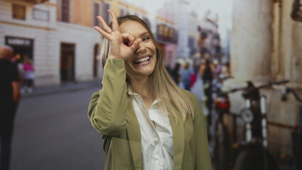 Fototapeta premium Woman smiling on city street outdoors showing ok gesture in modern urban setting.