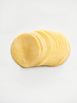 Neatly stacked fresh pasta sheets prepared for cooking. Ideal for use in restaurant menus, food blogs, and culinary tutorials to showcase homemade pasta