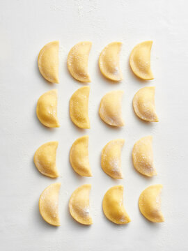 A uniform arrangement of ravioli dough ready for filling. Ideal for restaurant menus, food blogs, recipe books, and cooking classes
