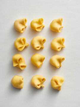 The image shows freshly made tortellini dough arranged neatly in rows. This scene is ideal for cooking blogs, restaurant menus, or culinary advertisements