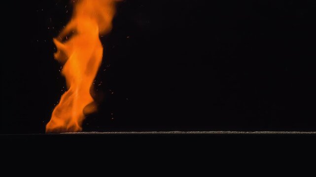 Burning Gunpowder on Black. A thin horizontal strip of gunpowder ignites at one end and gradually burns away against a black background