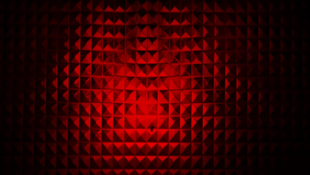 red abstrac background showcasing a geometric pyramidal texture bathed in a deep, glowing red light.