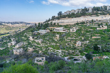 Obraz premium Panoramic view of Jerusalem neighborhoods, with the abandoned village of Lifta in the foreground, located on the slope of green hills in early spring.Israel.