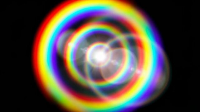 Circular light patterns in vibrant rainbow colors emerge from a bright center, creating a captivating visual effect against a dark backdrop