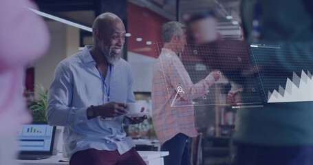 Smiling man in blue-shirt lanyard holding cup at office, reviewing AR as coworker points to laptop
