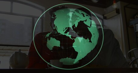 Projecting green hologram globe obscuring couple sitting at wood cafe table, with teapot, mug