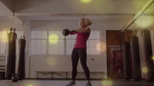 Midlife woman starting kettlebell overhead hinging swinging pressing returning for fitness