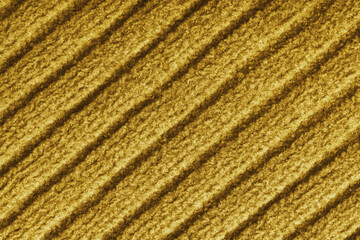 Close up, macro of yellow colored knitted fabric with diagonal relief ribbed pattern and soft wool texture. Detailed textile surface, knitwear background, fashion, backdrop, design element. © katyamaximenko