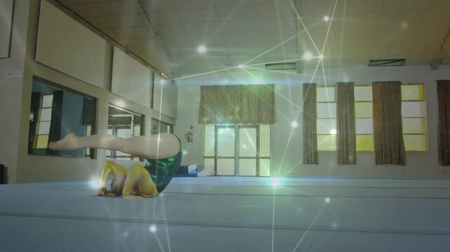 Vertical video: Swinging arms gymnast green leotard tucking rolling on gym spring mat with overlay