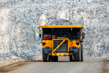 Massive Mining Dump Truck Transporting Ore in Open Pit Mine at Sunset © Parilov