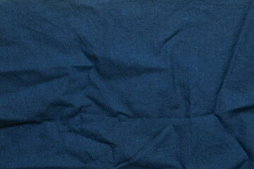 Abstract pattern and texture background of a worn, wrinkled, and creased dark blue handkerchief. For graphic design, 3D rendering and banners