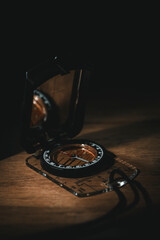 Vintage compass on wooden surface with mysterious smoke dark moody still life © Leonard