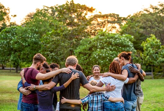 Diverse group hugging outdoors
