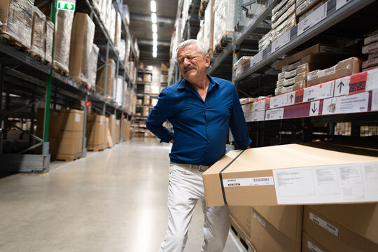 Man lifting box painfully.