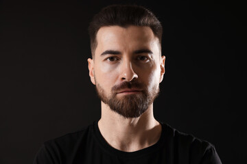 Obraz premium Portrait of serious man on black background