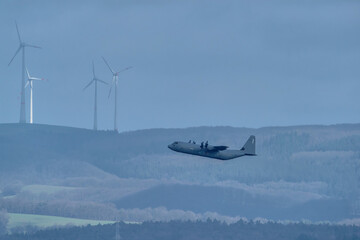 Fototapeta premium Military transport aircraft flying over landscape near Ramstein Air Base