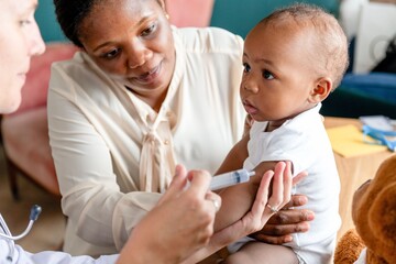 Obraz premium Doctor administering vaccine to infant.