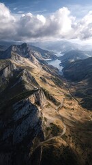 Naklejka premium Aerial view of a winding road through rugged mountains and a deep blue lake
