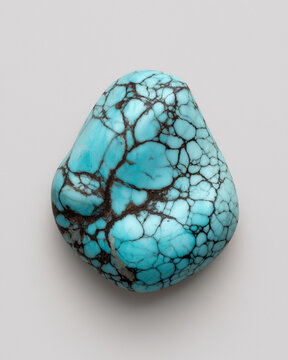 Polished Turquoise Nugget with Spiderweb Matrix &ndash; Studio Macro, High-detail turquoise stone with black matrix veins, glossy finish, isolated on a neutral backdrop&mdash;premium gemstone product shot.