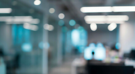 Fototapeta premium Blurred office interior showcases a modern workspace with computers, desks, and ambient lighting, creating a productive atmosphere that suggests business activities.