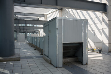 Metal ventilation equipment arranged in an industrial factory corridor with steel structures and tiled flooring
