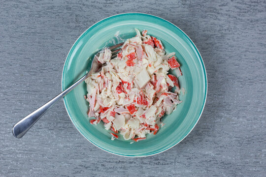 Bowl filled with creamy crab stick and mayonnaise salad, fork resting inside. Ready-to-use filling perfect for sandwiches, wraps, sushi, or appetizers. Versatile seafood mixture