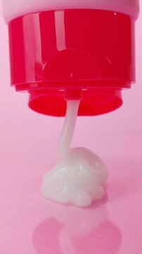 Stacking white serum on top of more serum creating a textured mound. Isolated on soft pink background, skincare product visualization, cosmetic texture close up.