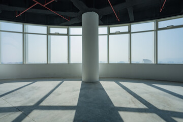 Obraz premium Empty modern office interior with circular floor-to-ceiling windows and central concrete column