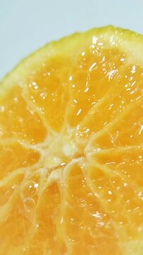 Extreme close up of a fresh orange slice showing juice flowing between the fruit fibers. Citrus texture, fruit food concept