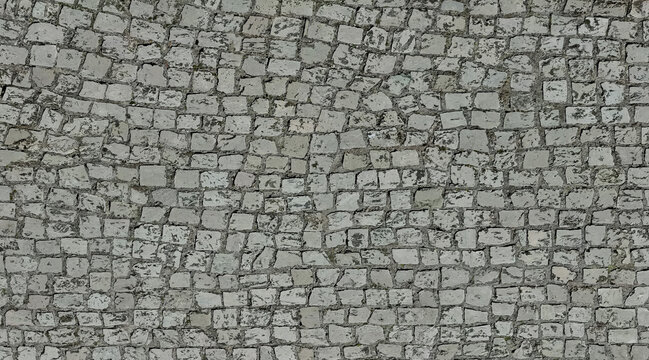 Top view of aged cobblestone footpath with irregular stone blocks forming a rustic pavement texture.
